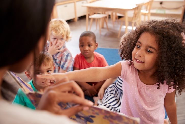 A person reading a book to children A person reading a book to children